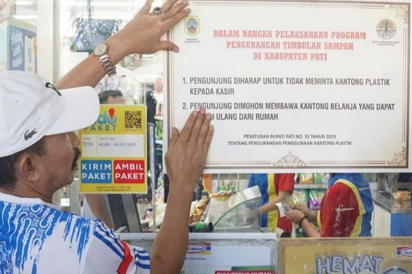 Bupati Pati, Haryanto, memasang stiker imbauan pengurangan plastik sekali pakai di sebuah toko modern di Kabupati Pati, Jateng, Jumat (26/7). (Foto: Instagram/@humassetdapati)