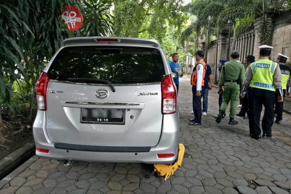 Petugas menggembok ban mobil yang parkir di tempat terlarang di salah satu jalan di Kota Surakarta, Jateng. (Foto: Instagram/@dishubsurakarta)