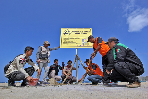Tim gabungan memasang papan peringatan rawan tsunami di salah satu pantai di selatan Jawa. (Foto: BNPB)