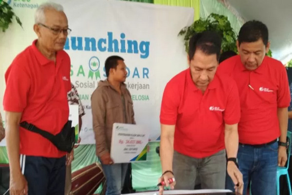 Pelaksana tugas Bupati Kudus, Hartopo, didampingi Kepala BPJS Ketenagakerjaan Cabang Kudus Ishak dan Kades Jati Kulon Sugeng menandatangani prasasti desa sadar wisata di kompleks Taman Bunga Celosia Desa Jati Kulon, Jati, Kudus, Minggu (1/9/2019). (Foto: Antara).