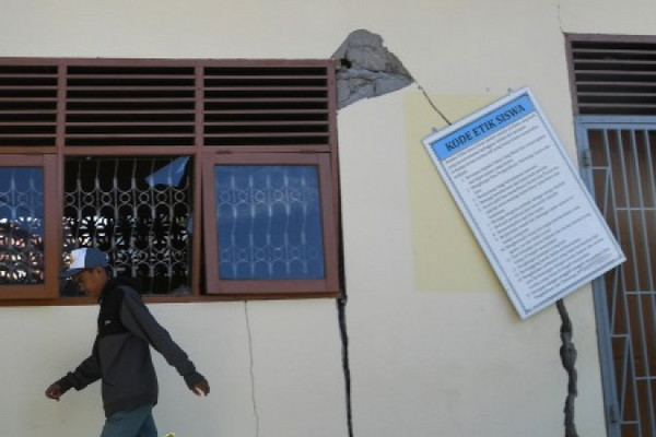 Siswa berjalan di depan bangunan yang rusak di SMA PGRI, Kota Palu, Sulteng, 8 Oktober 2018. (Foto: Antara Foto/Wahyu Putro A.) 
