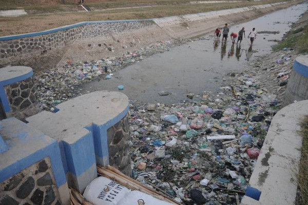 Warga mencari ikan di saluran irigasi yang mengering dan dipenuhi sampah plastik di Desa Menawan, Kabupaten Demak, Jateng, Sabtu (6/7). (Foto: Antara Foto/Yusuf Nugroho)