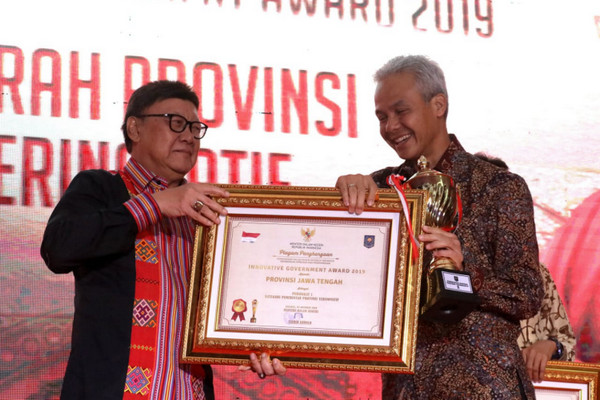 Mendagri, Tjahjo Kumolo (kiri), menyerahkan penghargaan provinsi inovatif 2019 kepada Gubernur Jateng, Ganjar Pranowo, di Jakarta, Senin (7/10) malam. (Foto: Pemprov Jateng)