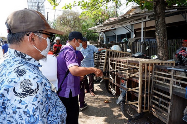 Petugas menyemprotkan disinfektan ke kandang unggas untuk mencegah penyebaran virus flu burung. (Foto: Pemkab Banjar)