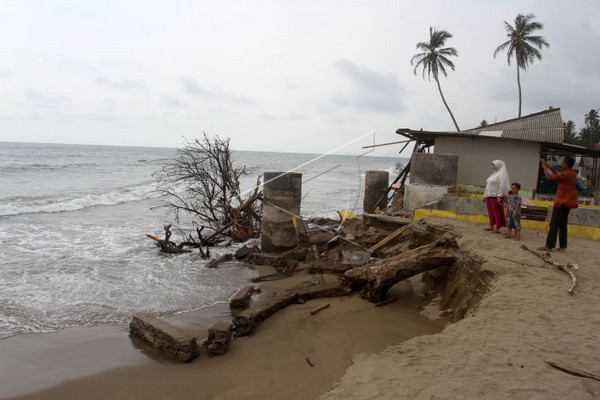 Sejumlah warga memperhatikan rumah yang hancur akibat abrasi pantai di Nagari Empat Koto Hilir, Kecamatan Batang Kapas, Kabupaten Pesisisir Selatan, Sumbar, Selasa (8/10). (Foto: Antara Foto/M. Arif Pribadi)