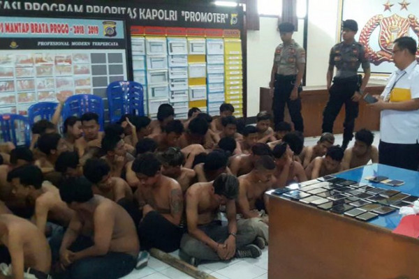 Puluhan suporter yang diamankan polisi usai kerusuhan di halaman parkir Stadion Mandala Krida, Kota Yogyakarta, DIY, Senin (21/10). (Foto: Antara/Luqman Hakim)