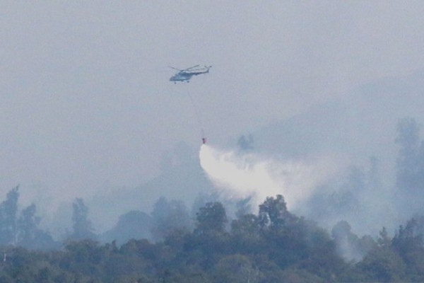 Helikopter BNPB melakukan bom air di atas hutan  yang terbakar di Cagar Alam Merapi Ungup-Ungup, Kabupaten Banyuwangi, Jatim, Rabu (30/10). (Foto: Antara Foto/Budi Candra Setya)