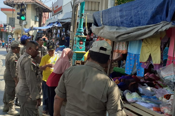 Personel Satpol PP menegur para PKL yang berjualan di trotoar dan tepi jalan sekitar Pasar Induk, Kabupaten Brebes, Jateng, Kamis (31/10). (Foto: Twitter/@Satpolpp_brebes)