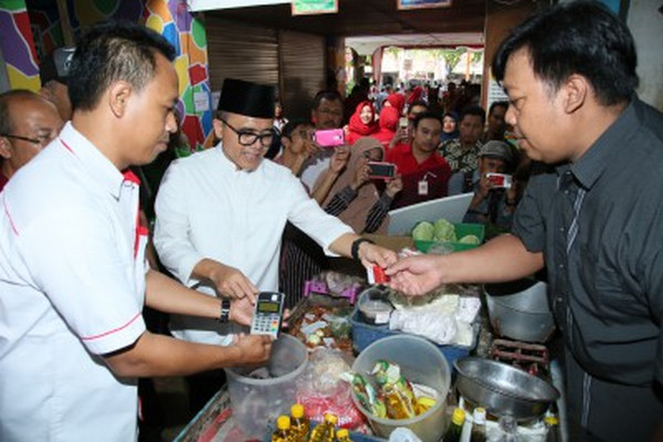 Bupati Banyuwangi, Abdullah Azwar Anas (tengah), mencoba penerapan retribusi-el kala peluncuran sistem tersebut di Pasar Blambangan, Kabupaten Banyuwangi, Jateng, 17 September 2017. (Foto: Pemkab Banyuwangi)