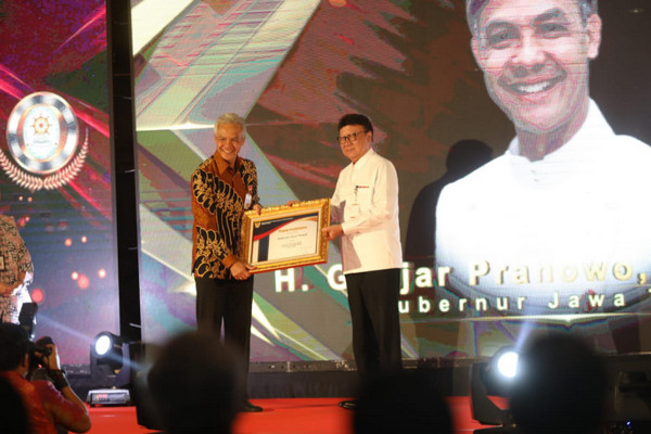 Kemenpan RB, Tjahjo Kumolo (kanan), menyerahkan penghargaan Pembinan Pelayanan Publik kepada Gubernur Jateng, Ganjar Pranowo, di Jakarta, Selasa (5/11). (Foto: Pemprov Jateng)