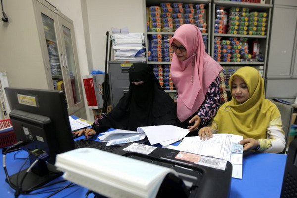 Seorang ASN bercadar (kiri) beraktivitas di Dukcapil Pemkot Banda Aceh, Aceh, Jumat (1/11). (Foto: Antara Foto/Irwansyah Putra)