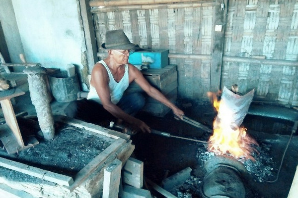 Seorang pandai besi, Darto (70), tengah membakar cangkul agar mudah dalam pembuatannya. Bengkelnya berada di Kecamatan Jakenan, Kabupaten Pati, Jateng. (Foto: Pemkab Pati)