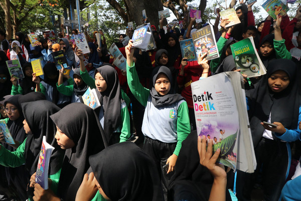Sejumlah pelajar mengangkat buku bacaan miliknya, sebelum saling tukar di Hutan Kota Joyoboyo, Kota Kediri, Jawa Timur, Sabtu (16/11/2019). Kegiatan yang diselenggrakan Pemerintah daerah setempat tersebut untuk mendorong minat baca pelajar sekaligus sebagai solusi mendapatkan buku yang disuka tanpa membeli. (Foto&keterangan: Antara Foto).