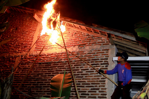 Petugas pemadam kebakaran tengah mengevakuasi sarang tawon dengan cara dibakar di rumah seorang warga Kelurahan Kedungpane, Kecamatan Mijen, Kota Semarang, Jateng, 7 Mei 2018. (Foto: Pemkot Semarang)