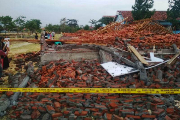 Garis polisi melintang di sekitar bangunan kelas SMKN 2 Songgom yang roboh akibat hujan deras dan angin kencang di Kabupaten Brebes, Jateng, Minggu (24/11). (Foto: Twitter/@penrem071_wk)