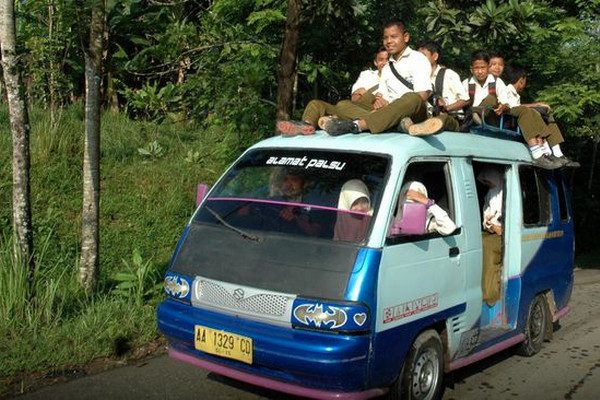 Sejumlah pelajar naik angkudes dengan menumpang di atap kendaraan di Karangayam, Kabupaten Kebumen, Jateng, Rabu (28/1). (Foto: Antara Foto/Aditya Pradana Putra)