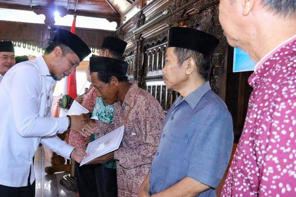 Plt Bupati Kudus, Hartopo (kiri), secara simbolis menyerahkan bansos kepada para pemuka agama se-Kabupaten Kudus, Jateng, Kamis (28/11). (Foto: Twitter/@Pemkab_Kudus)