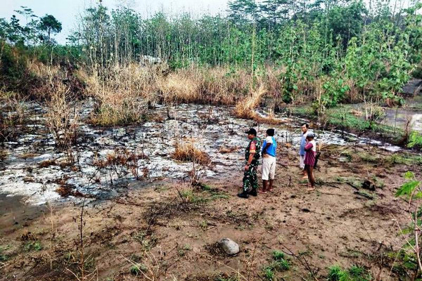 Lahan perkarangan warga terbakar akibat terkena limbah B-3 cair yang diduga dari PT RUM dan dibuang di Desa Kutamendala, Kecamatan Tonjong, Kabupaten Brebes, Jateng, Sabtu (30/11). (Foto: Facebook/Penerangan Kodim Brebes)