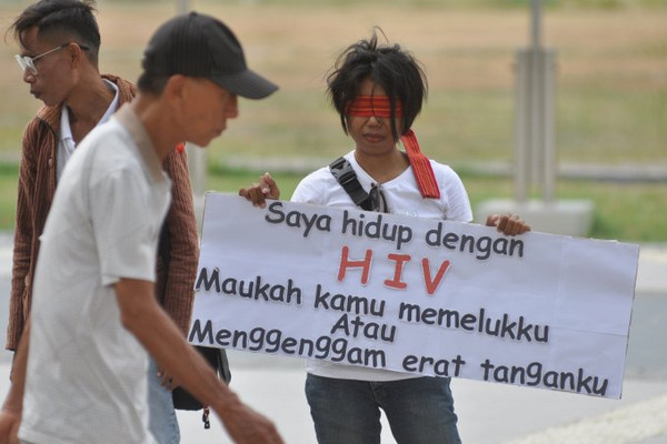Peserta aksi memegang poster saat mengikuti aksi peringatan Hari AIDS Sedunia di Lapangan Vatulemo, Kota Palu, Sulteng, Minggu (1/12). (Foto: Antara Foto/Mohamad Hamzah)