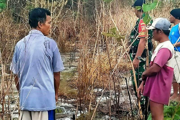 Masyarakat meninjau lahan perkarangan yang terbakar akibat tercemar limbah B-3 cair yang diduga dari PT RUM dan dibuang di Desa Kutamendala, Kecamatan Tonjong, Kabupaten Brebes, Jateng, Sabtu (30/11). (Foto: Facebook/Penerangan Kodim Brebes)