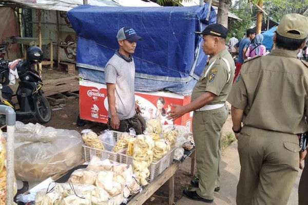 Petugas Satpol PP tengah berbincang dengan pedagang pasar tiban di Jalan Pelita II, Kota Pekalongan, Jateng. (Foto: Pemkot Pekalongan)