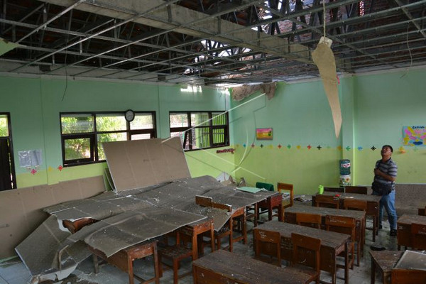 Warga melihat kerusakan ruang kelas III MTs Negeri 12 Desa Nglele yang rusak diterjang angin kencang di Kecamatan Sumobito, Kabupaten Jombang, Jatim, Minggu (1/12). (Foto: Antara Foto/Syaiful Arif)