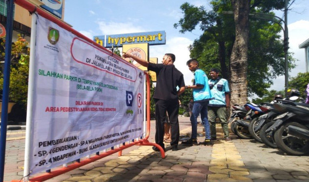 Sejumlah petugas parkir saat mengarahkan pengendara sepeda motor yang mau parkir di Citywalk Jalan Slamet Riyadi Solo, Senin (6/1). (Foto: ANTARA))