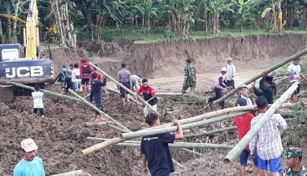 Sejumlah warga bersama TNI dan Polri membantu perbaikan tanggul Sungai Tuntang di Kecamatan Gubug, Kabupaten Demak, Jawa Tengah, Jumat (10/1/2020). (ANTARA)