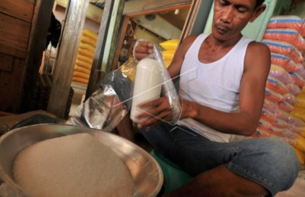 Seorang pedagang mengikat bungkusan gula pasir kiloan. (Foto ANTARA)