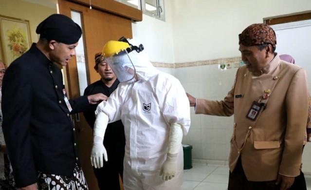 Gubernur Jawa Tengah Ganjar Pranowo berbincang dengan tenaga medis RSUD Tugurejo yang mengenakan alat pelindung diri lengkap saat meninjau kesiapan rumah sakit menangani kasus COVID-19. (ANTARA)