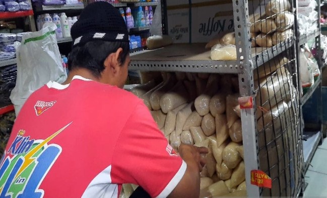 Seorang pedagang sembako saat melayani para pembeli gula pasir di Pasar Tradisional Sidodadi Kleco Solo, Jateng, Jumat (13/03). (ANTARA)