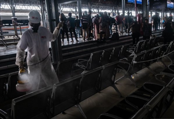 Petugas menyemprotkan cairan disinfektan di area ruang tunggu penumpang Stasiun Tawang, Semarang, Jawa Tengah, Minggu (15/3/2020). ANTARA