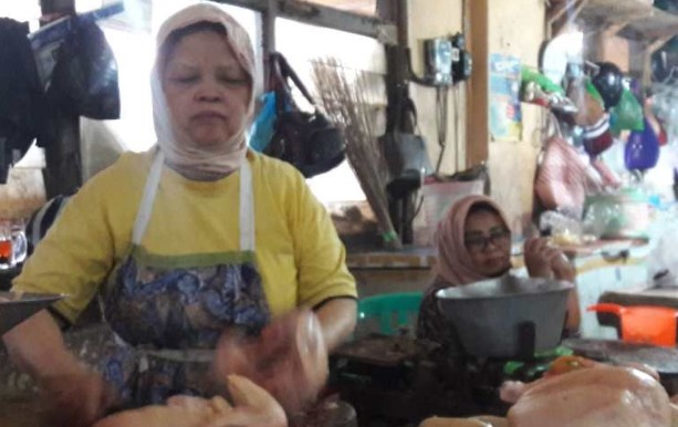 Seorang pedagang daging ayam di Pasar Kliwon Temanggung melayani pembeli. (ANTARA/Heru Suyitno)