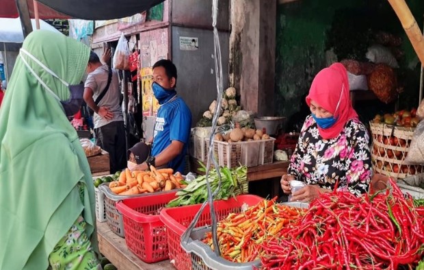 Seorang pedagang komoditas sayuran saat melayani pembeli di Pasar Sidodadi Laweyan Solo, Jateng, Jumat (8/5/2020). (ANTARA/Bambang Dwi Marwoto)