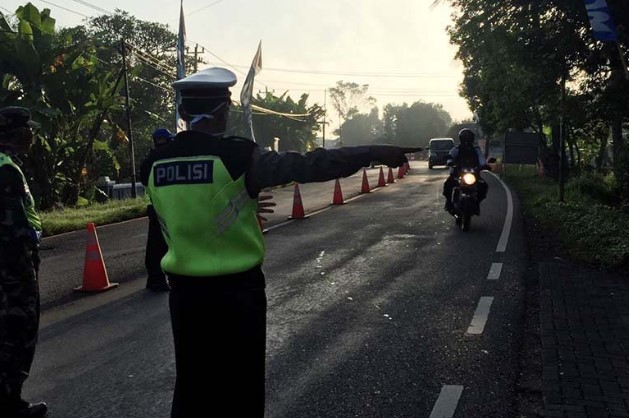 Petugas gabungan saat mengarahkan pemudik untuk menjalani pemeriksaan di Posko Terpadu Operasi Ketupat Candi Tahun 2020 dan COVID-19 Perbatasan Banyumas yang berlokasi di Jembatan Timbang Ajibarang, Kabupaten Banyumas, Jawa Tengah. ANTARA/HO-Polresta Banyumas