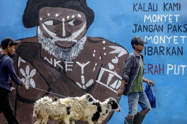 Warga melintas di depan mural bertema antirasial di Jalan Raya Bogor, Kota Depok, Jabar, Selasa (28/7/2020). Foto Antara/Yulius Satria Wijaya
