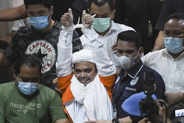 Pentolan FPI, Rizieq Shihab (baju tahanan), saat berjalan menuju mobil tahanan usai diperiksa di Mapolda Metro Jaya, Jakarta, Minggu (13/12/2020). Foto Antara/Hafidz Mubarak A.