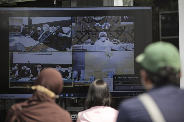 Layar menampilkan suasana sidang perdana kasus pelanggaran prokes dengan terdakwa Rizieq Shihab di PN Jaktim, Jakarta, Selasa (16/3/2021). Foto Antara/Dhemas Reviyanto