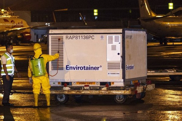 Petugas menyemprotkan disinfektan ke kontainer berisi vaksin Covid-19 saat tiba di Bandara Soekarno-Hatta, Tangerang, Banten, Minggu (6/12/2020). Foto Antara/Dhemas Reviyanto