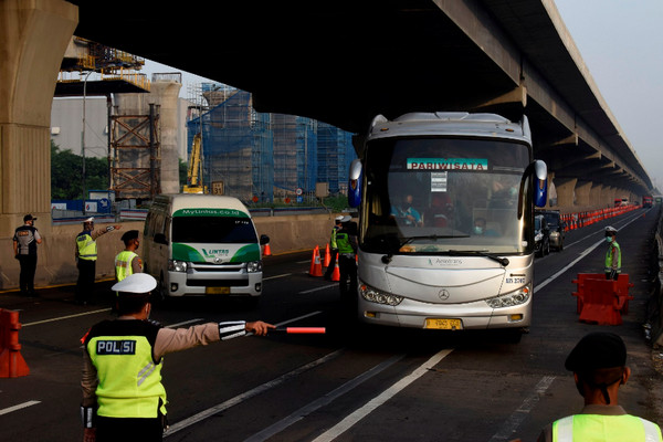 Petugas kepolisian mengarahkan kendaraan pribadi di tol Jakarta-Cikampek untuk memutar balik karena larangan mudik di pintu tol Cikarang Barat, Jawa Barat, Kamis (7/5/2020). Foto Antara/Sigid Kurniawan