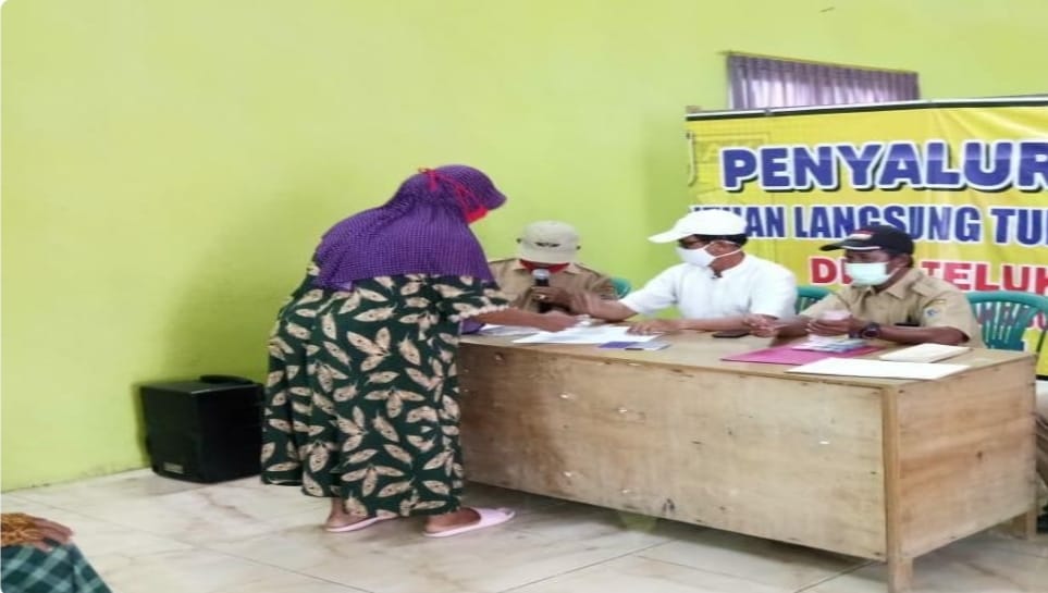 Pemdes Teluk, Kabupaten Demak menyalurkan bantuan BLT-DD Tahap V 2021 kepada seorang warga, Selasa (29/6). (Foto: Laman dinkominfo.demakkab.go.id)