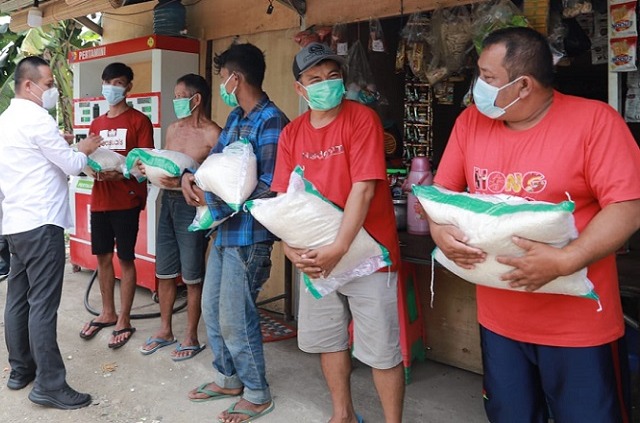 Bupati Kebumen, Arfi Sugiyanto (baju putih) menyalurkan beras kepada masyarakat di Kecamatan Karangsambung, (21/7). (Foto: Laman kebumenkab.go.id).