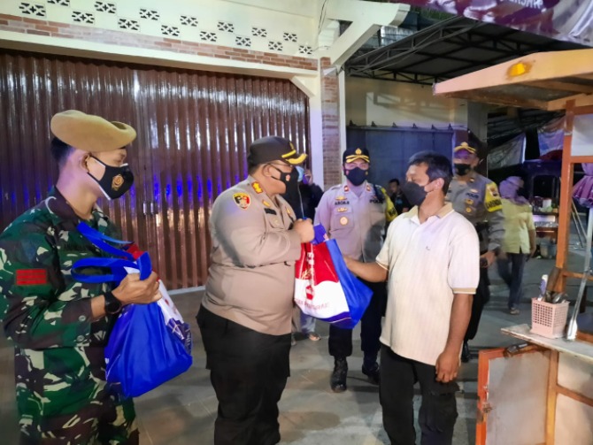 Kapolres Magelang, AKBP Ronald A Purba menyerahkan paket sembako bagi warga. (Foto: Laman beritamagelang.id)