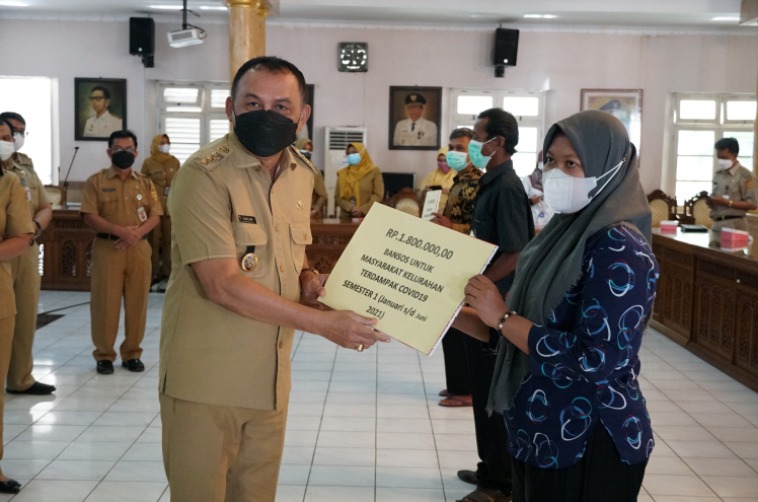 Bupati Purworejo, Agus Bastian menyerahkan bansos Rp1,8 juta bagi warga. (Foto: Laman purworejokab.go.id)