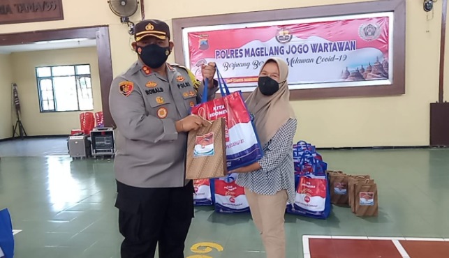 Kapolres Magelang, AKBP Ronald A. Purba menyerahkan bantuan PPKM bagi wartawan. (Foto: Laman beritamagelang.id).