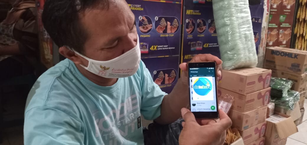 Salah satu pedagang pasar di Batang menunjukkan aplikasi Dotukura. Foto: jatengprov.go.id