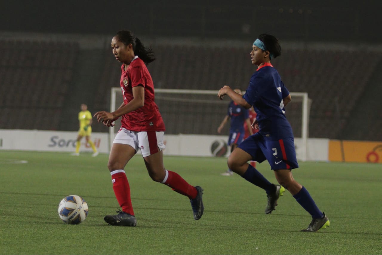 Pemain timnas perempuan berebut bola dengan pemain Singapura. Foto: pssi.com