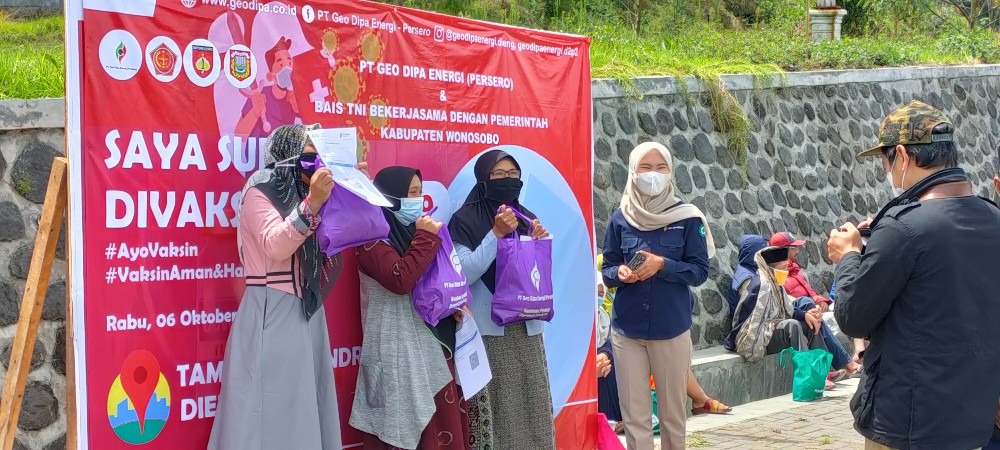 Pelaku wisata berfoto usai menadapatkan vaksin di Taman Syailendra, Desa Dieng Wetan. Foto: jategprov.go.id
