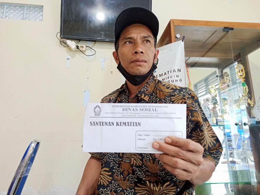 Salah satu ahli waris saat menerina santunan kematian dari Dinsos Temanggung. Foto: temanggungkab.go.id