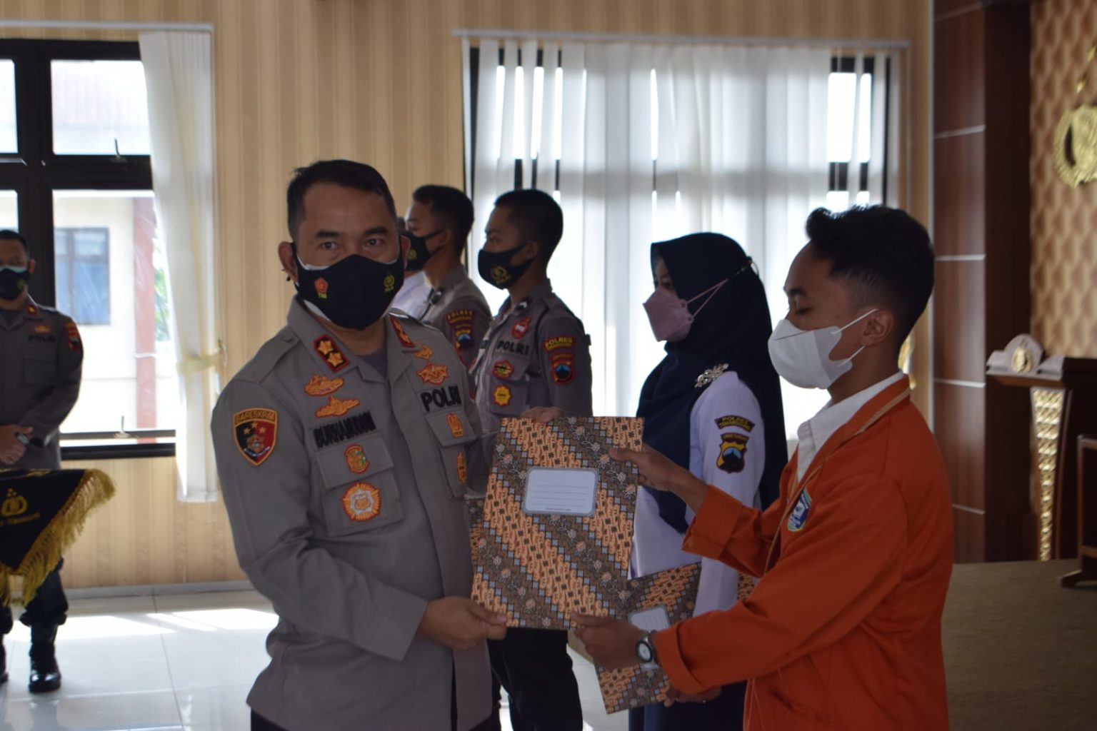 Kapolres Temanggung, AKBP Burhanuddin saat menyerahkan bingkisan kepada peserta vaksinasi. Foto: jategprov.go.id